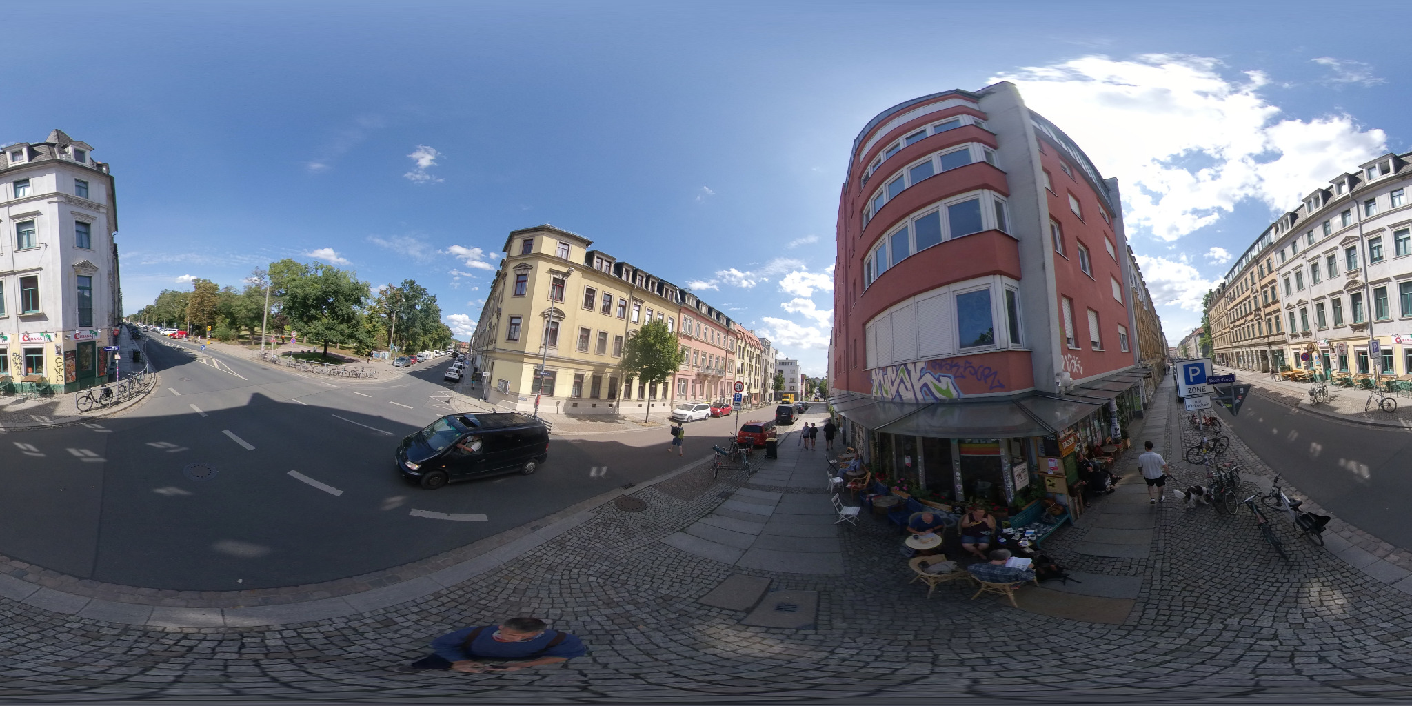 Rundumpanorama einer Straßenkreuzung mit Häusern und Außensitzplätzen